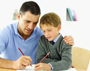 Padre ayuda a su hijo a realizar las tareas.